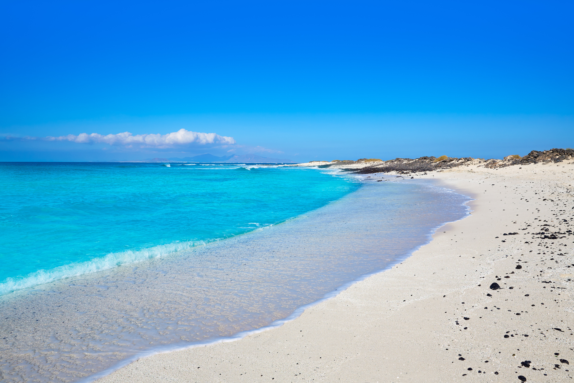 A beach and sea in a Canaries Island with an aqua blue sea