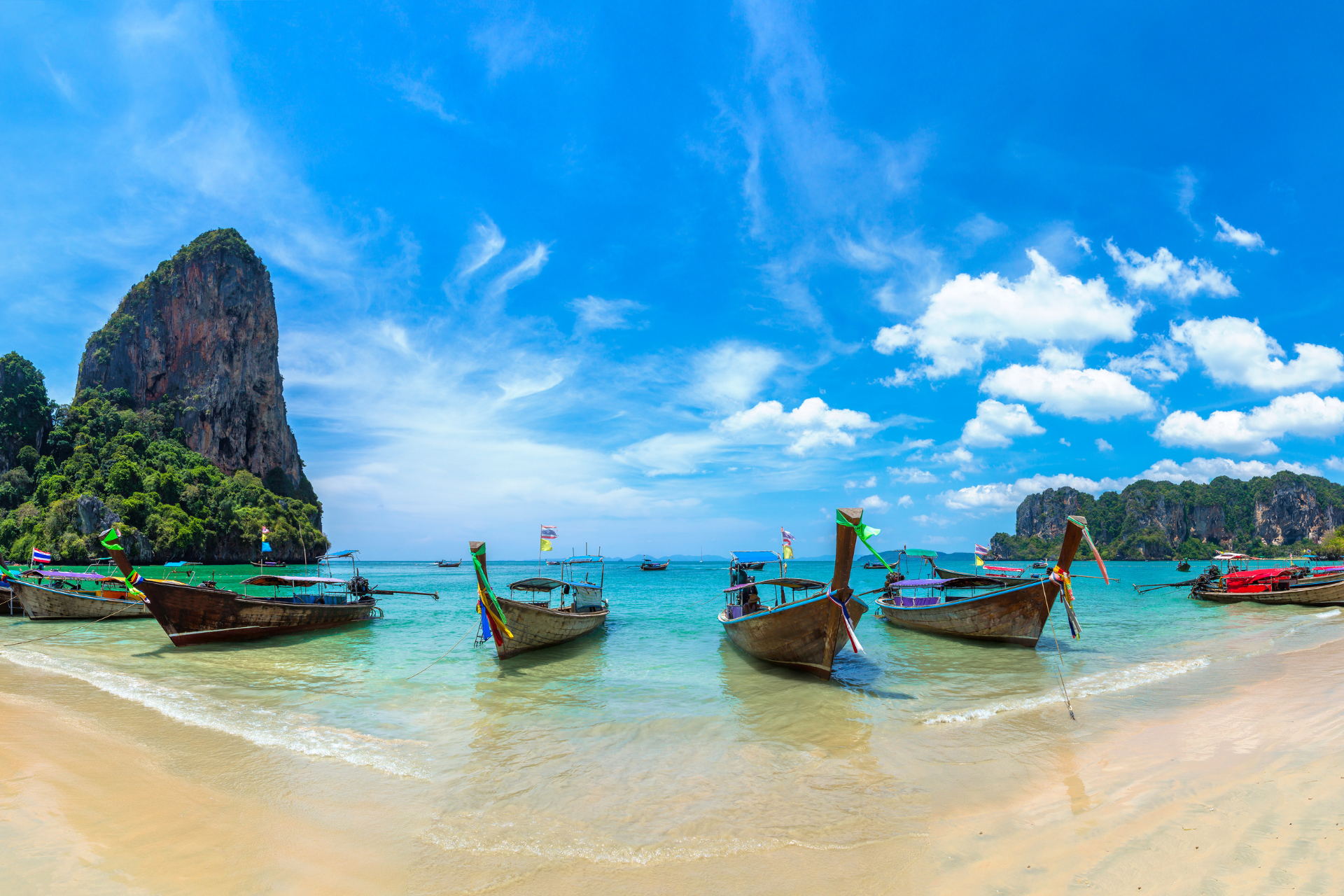 traditional thai boats on a beach on a thailand island hopping pre cruise stay