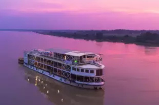 MV Bengal Ganga river cruise ship sailing with a purple sunset sky