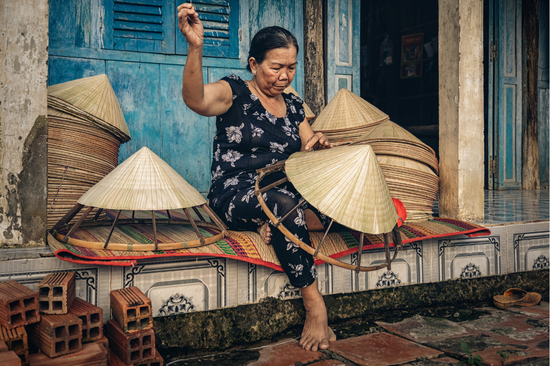 vietnamese old woman craftsman making the traditional hat
