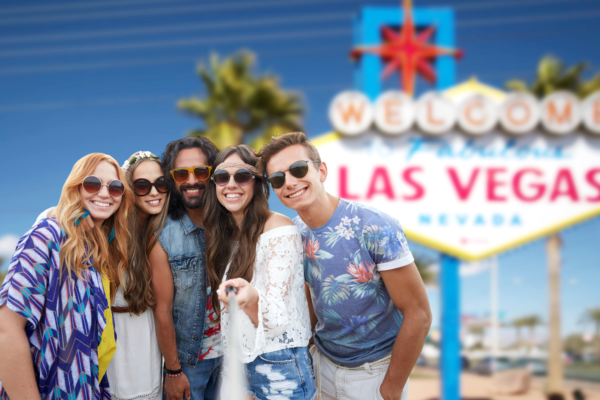 Tourists pose in front of a Las Vegas sign